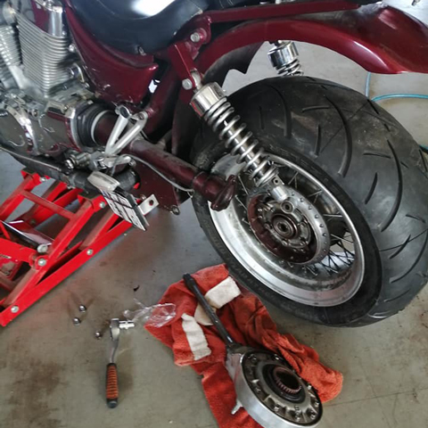 Motocykel s novými zadnými pneumatikami namontovaný na zdvíhacej plošine